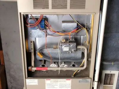 Heating system interior showing electrical connections, gas valve, and wiring, relevant to HVAC maintenance and efficiency.