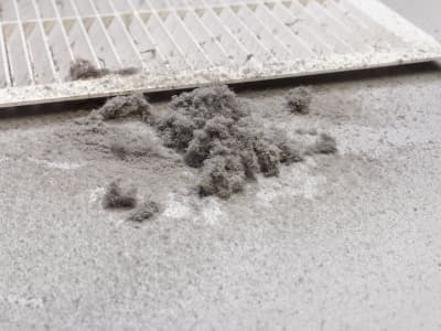 Dust accumulation around air duct filter, indicating potential need for air duct repair and maintenance.