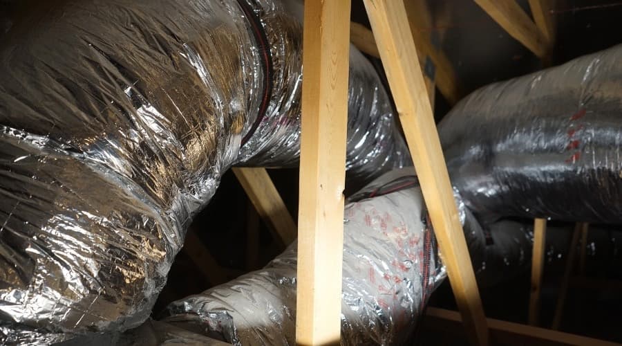 Insulated air ducts in an attic space, illustrating the hidden components of HVAC systems crucial for air quality and efficiency.