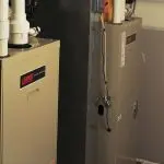 Two metal heating units with labeled controls and gas pipes in a functional HVAC maintenance space.