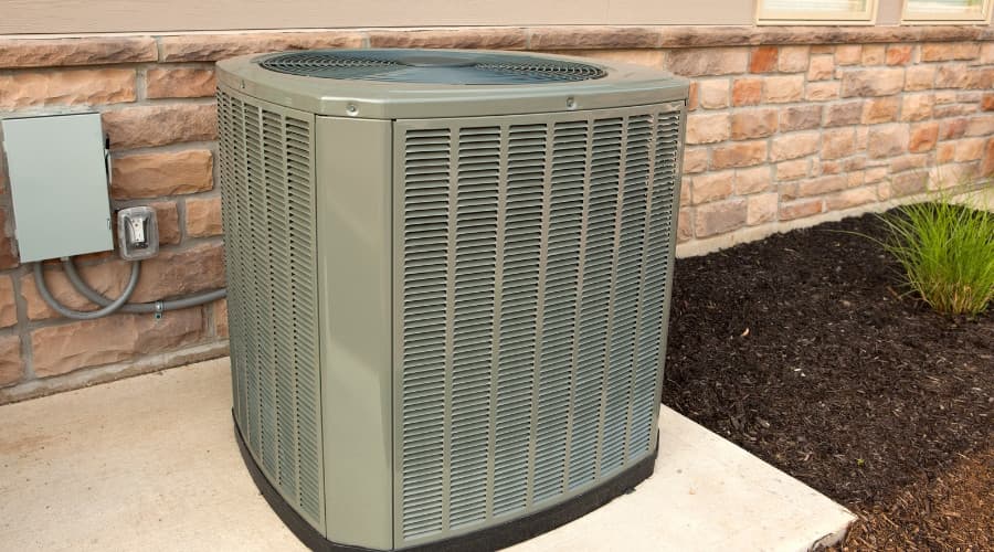 Air conditioning unit installed outside a home, highlighting HVAC system maintenance importance for energy efficiency and cooling performance.