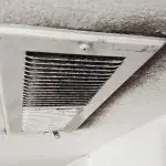 Ceiling vent with dust accumulation in a minimalistic space, highlighting HVAC service needs by Jerry Brittingham A/C & Heat.