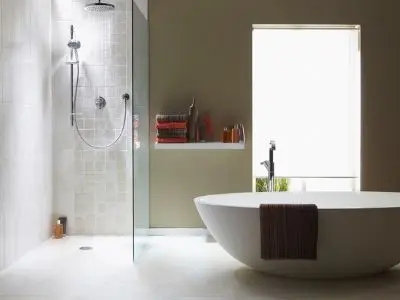 Modern bathroom featuring a sleek freestanding bathtub and a glass shower enclosure, emphasizing water conservation methods in home design.