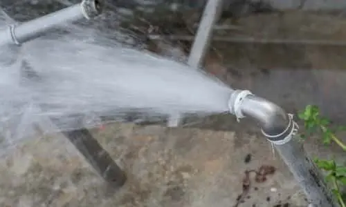 Burst pipe spraying water, highlighting plumbing issues relevant to homeowners.