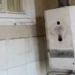Old water heater showing signs of wear and discoloration, indicating potential rust damage and the need for replacement, relevant to plumbing maintenance concerns.