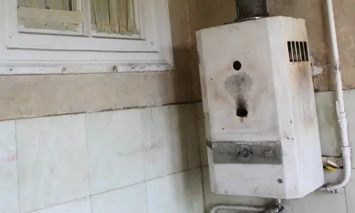 Old and worn water heater showing signs of age and potential malfunction, emphasizing the importance of replacement for homeowners during the holiday season.