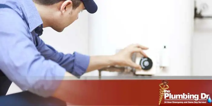 Technician adjusting water heater settings for installation services by The Plumbing Dr., emphasizing professional plumbing expertise in Arlington, VA.