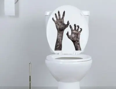 Toilet decorated with spooky bloody handprints on the lid, enhancing Halloween bathroom decor.
