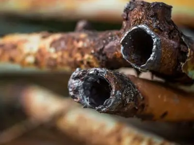 Corroded pipes showing significant rust and deterioration, illustrating plumbing issues common in older homes.