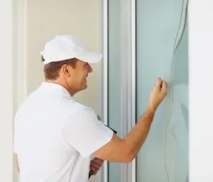 Plumber inspecting window seal, emphasizing home repair services in Arlington, VA.