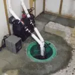 Sump pump installation featuring a primary and backup system in a basement, highlighting plumbing solutions for homeowners.