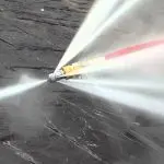 Hydrojetting nozzle spraying high-pressure water to clear sewer line clogs, illustrating effective plumbing services by The Plumbing Dr.