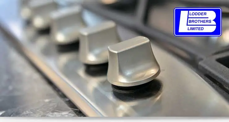 Gas appliance control knobs on a stainless steel surface with Lodder Brothers Limited logo, representing installation and repair services in Guelph, ON.