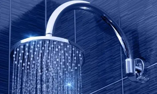 Eco-friendly showerhead with water cascading, highlighting water-saving technology, in a modern bathroom setting.