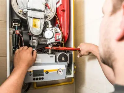 Technician performing maintenance on a boiler, checking internal components and ensuring efficient operation for winter readiness.