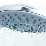 Chrome showerhead with water droplets, highlighting cleanliness for Charles Krull & Son, Inc. plumbing services.