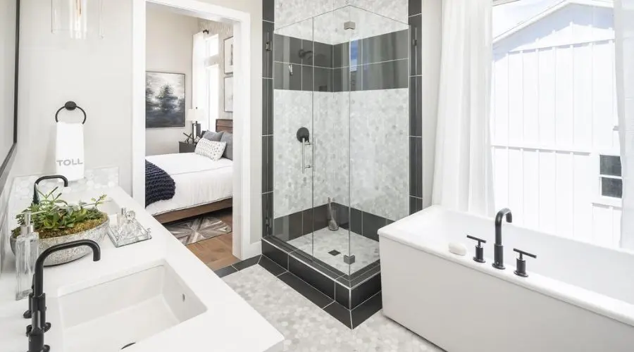 Modern bathroom interior featuring a glass shower, freestanding bathtub, dual sinks with stylish fixtures, and natural light from a window, reflecting a blend of functionality and aesthetic appeal.