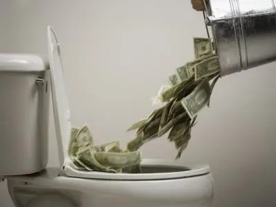 Money being dumped into a toilet, symbolizing wasted resources due to plumbing issues like slab leaks.