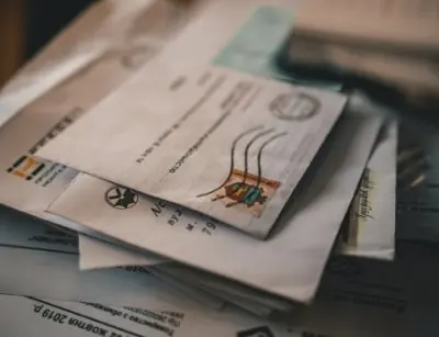 Stack of letters and envelopes, symbolizing communication and personal connections, relevant to Lillian Baumbach's role as a penpal for soldiers during the Korean War.