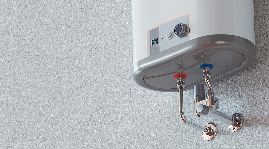 Tankless water heater mounted on wall with visible water inlet and outlet connections, showcasing modern plumbing technology relevant to home heating solutions.