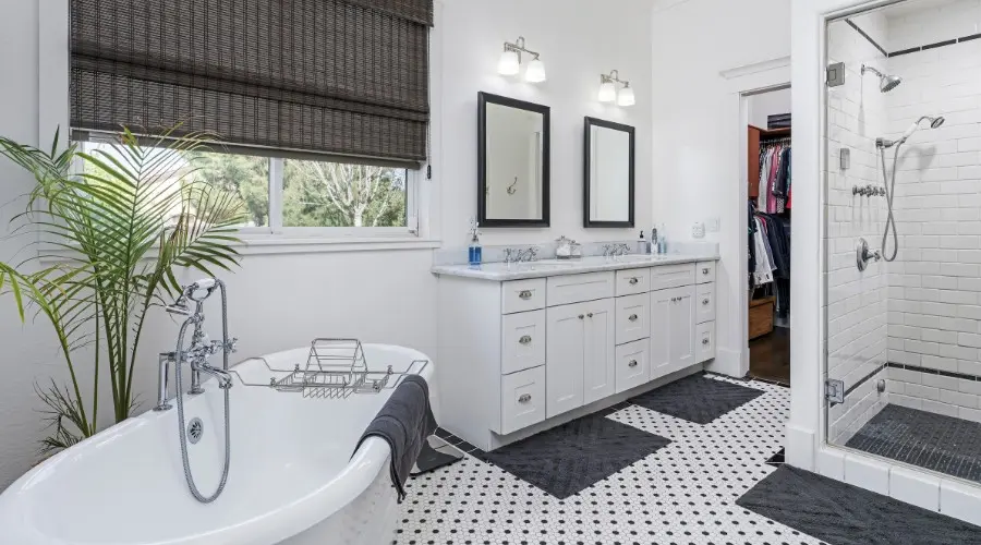 Modern bathroom interior featuring a freestanding bathtub, double vanity with mirrors, and a glass-enclosed shower, emphasizing stylish remodeling and plumbing upgrades.