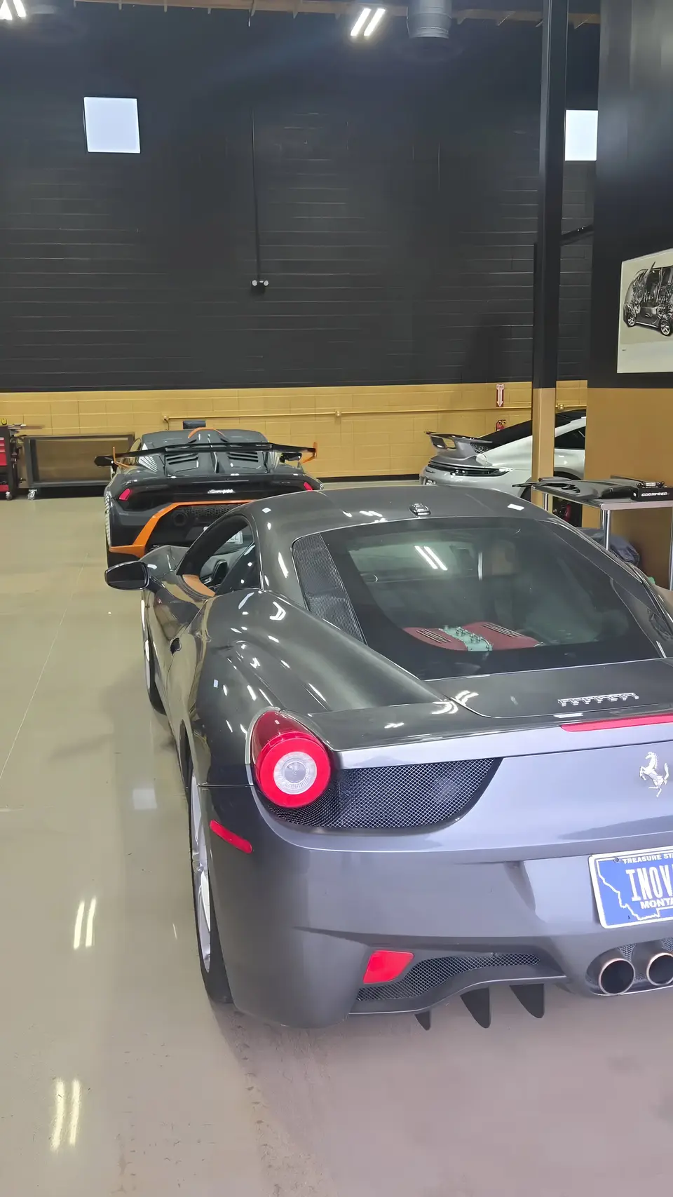 Aces Auto Elite - A gray Ferrari sports car is parked inside a luxury garage, where high-end vehicles await expert service. The space is well-lit with polished floors and modern decor, highlighting the area’s commitment to premium repair and care. | Arizona Luxury & Exotic Car Service
