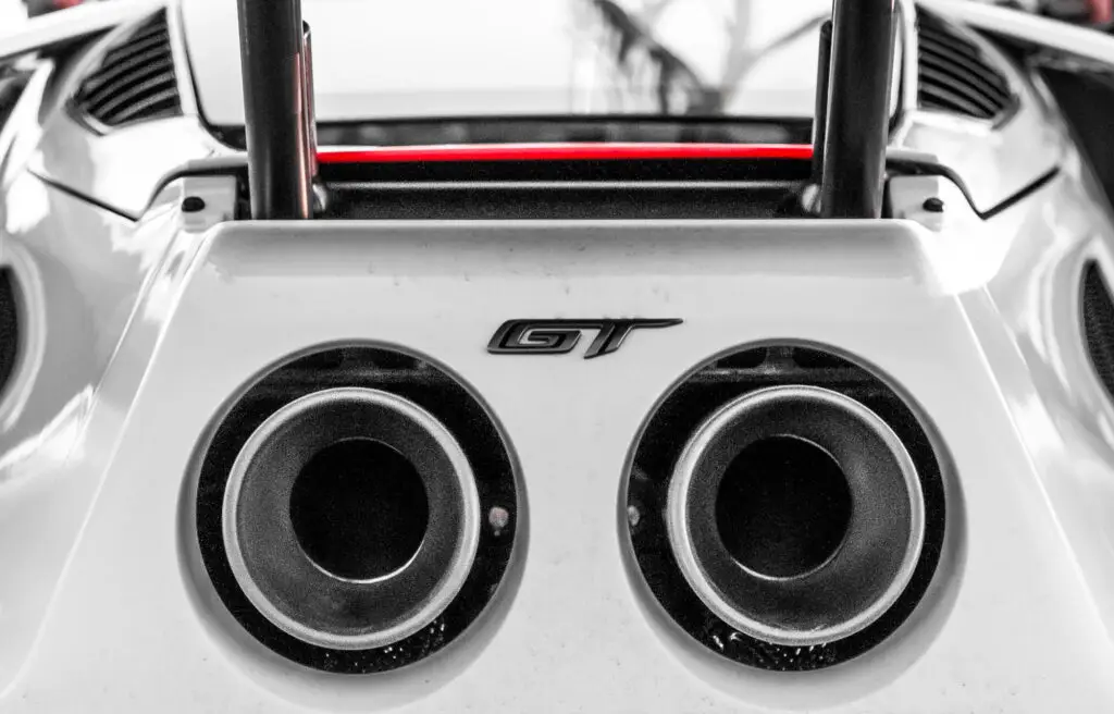 Aces Auto Elite - Close-up view of the rear exhaust pipes of a sports car, with the GT badge between the two circular pipes. The image highlights the car's aerodynamic design and metallic finish, ideal for showcasing advanced features like ADAS Calibration. | Arizona Luxury & Exotic Car Service