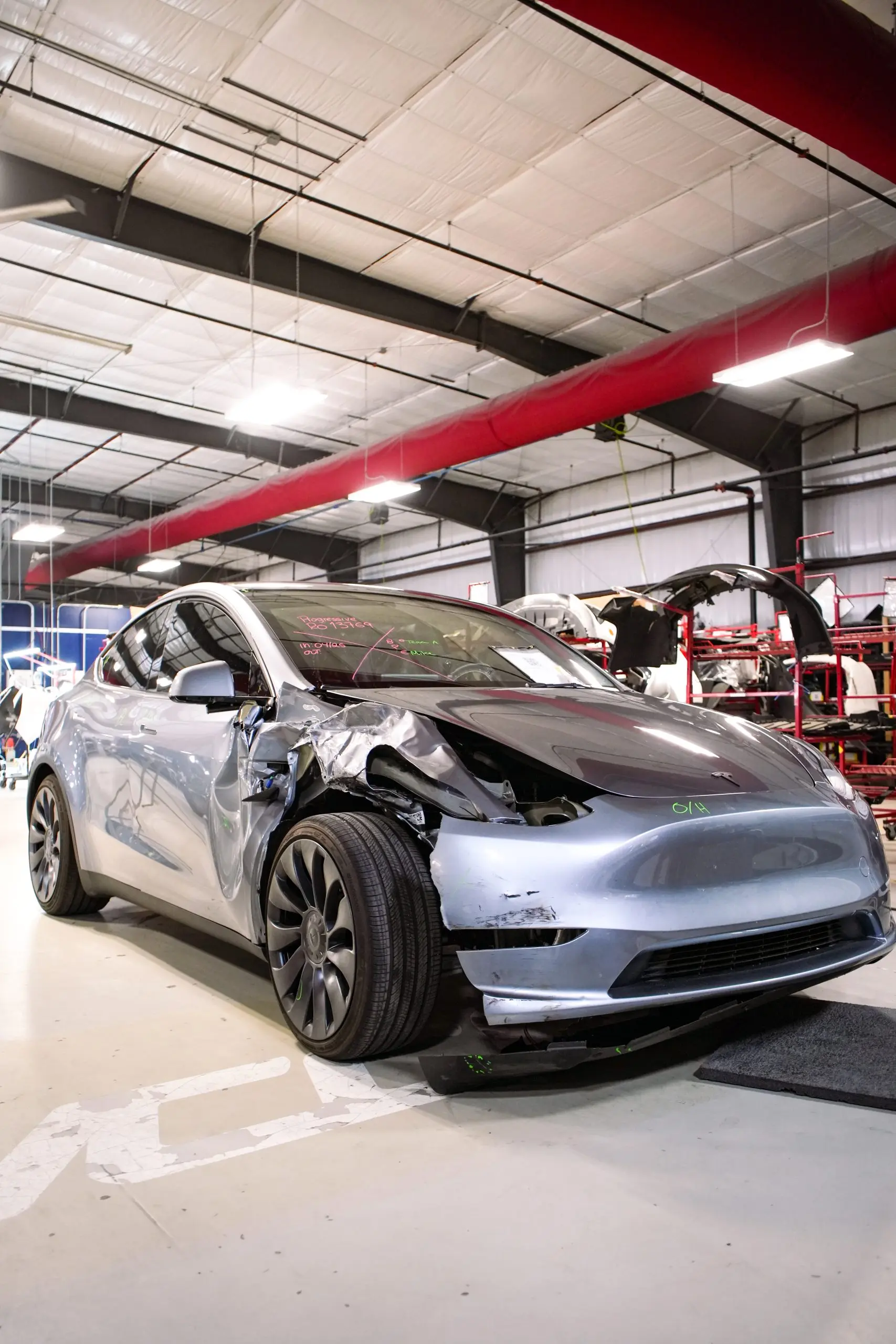 a damaged grey Tesla Model Y in need of collision repair