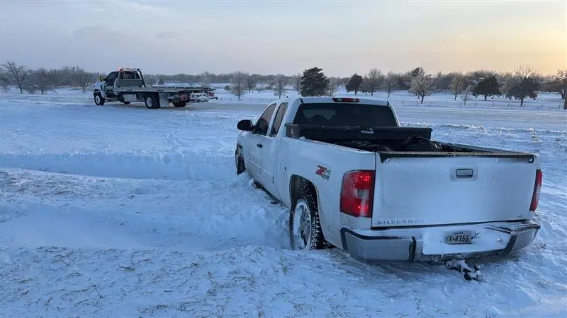 Dacus tow truck driver hooking up a vehicle for a tow in mcpherson, KS