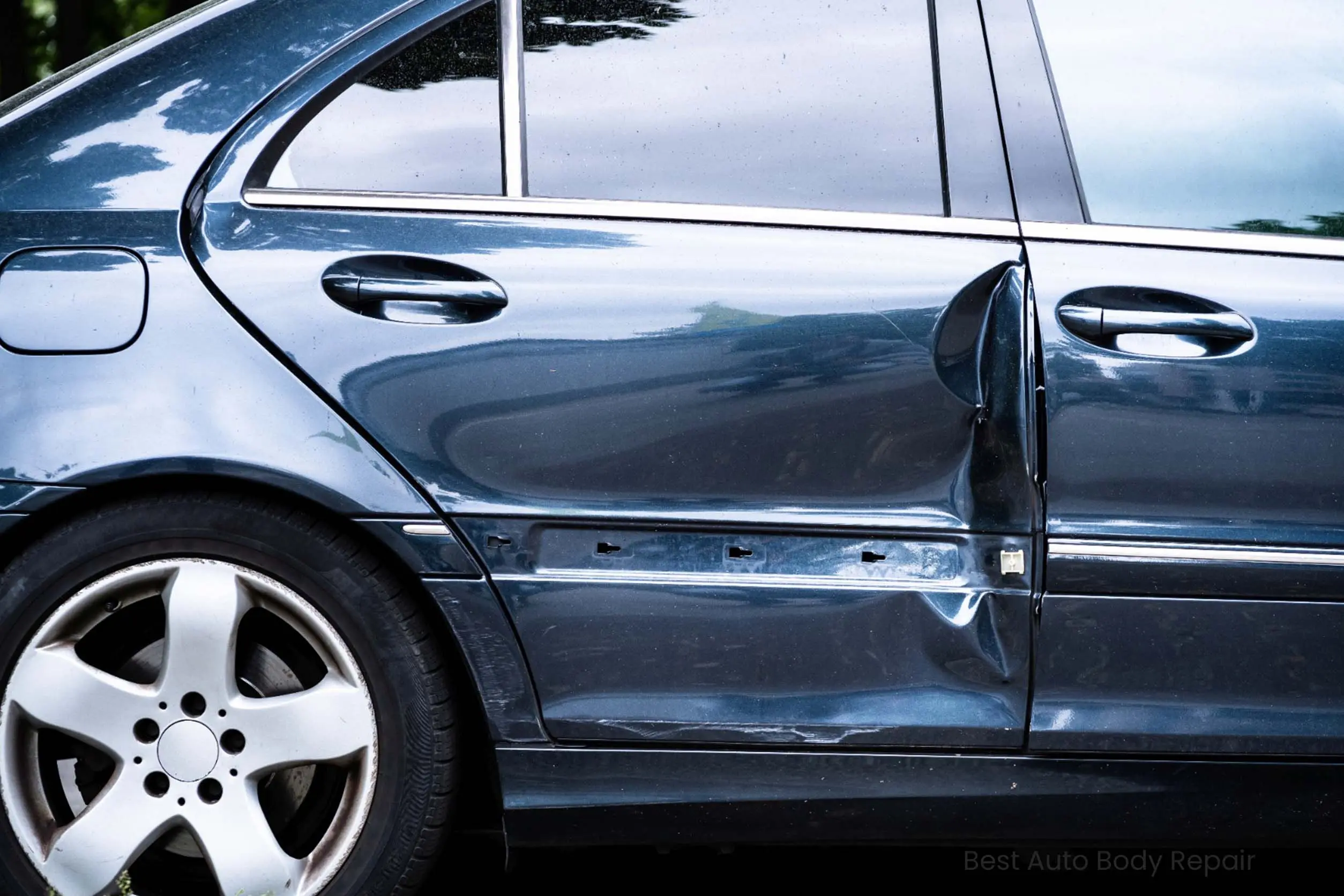 Vehicle door panel showing damage before auto body repair