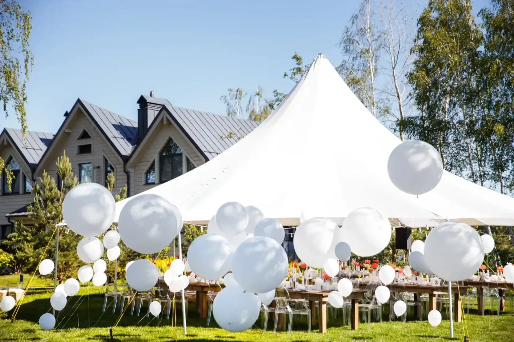 White wedding tent rental set up in a Chicagoland backyard with elegant outdoor reception tables and balloon d&eacute;cor