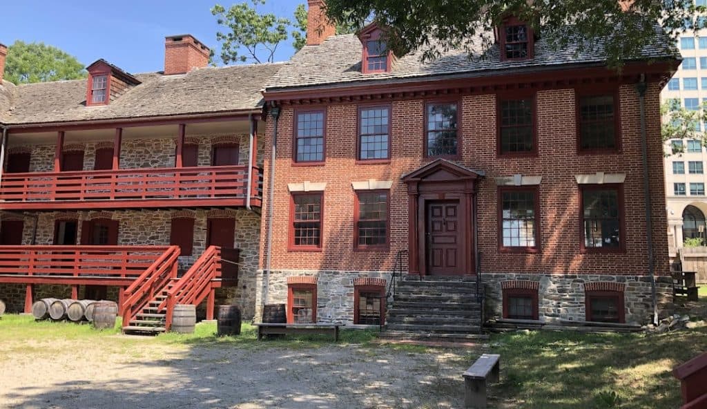 Historic building in Morrisville, PA, featuring red brick exterior, wooden balconies, and stairs, representing the area's architectural heritage and context for Aqua Dry Basement Waterproofing services.