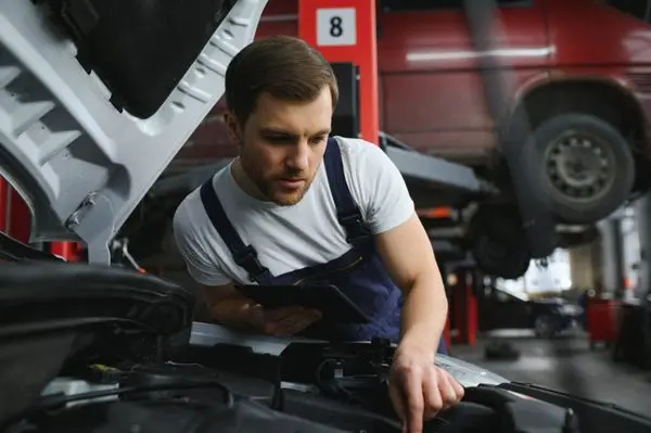 car mechanic using digital tablet with service