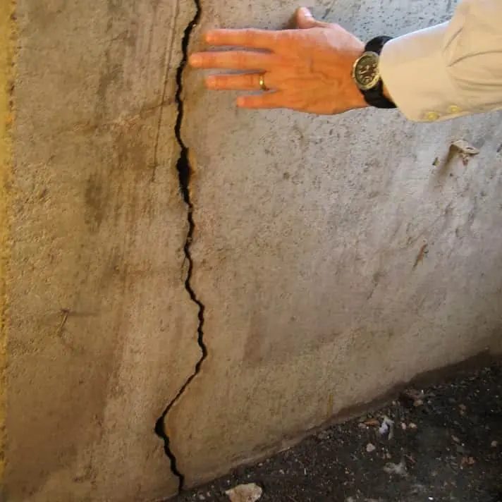 Large vertical foundation wall crack indicating potential structural damage in a basement