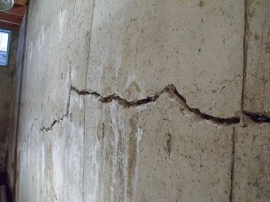 Horizontal crack and bowing concrete basement wall showing foundation pressure damage