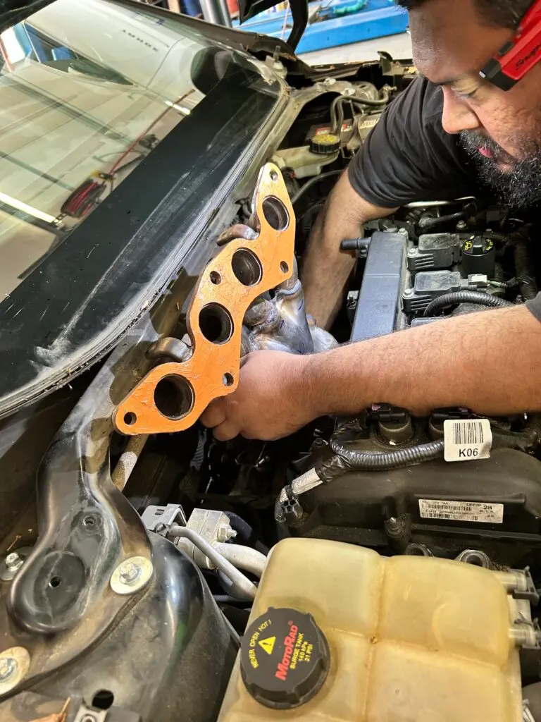 Technician diagnosing and repairing engine issue causing check engine light