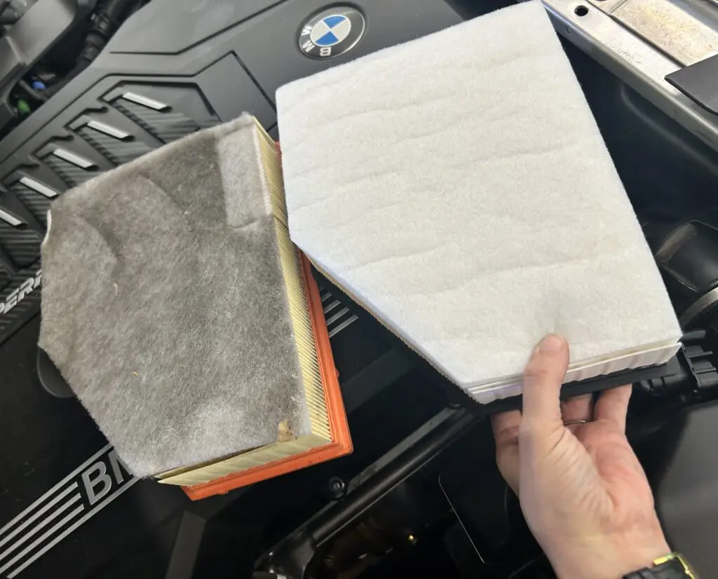 Dirty and clean BMW engine air filters during routine maintenance service at Chimney Rock Car Care in Houston, TX