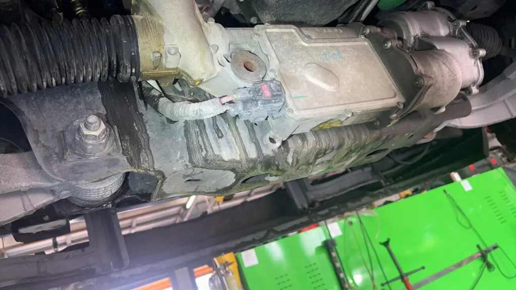 Coolant leaking from the underside of a vehicle indicating a cooling system leak.