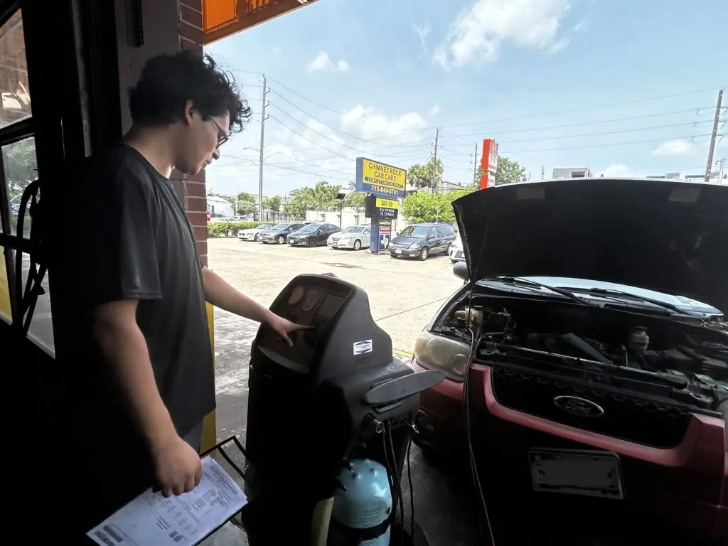 Technician performing A/C blow cold then warm service and refrigerant testing in Houston, TX