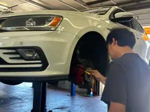 Technician measuring brake pad thickness during a brake inspection at Chimney Rock Car Care in Houston