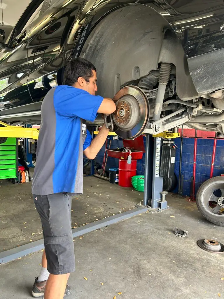 Brake repair technician working on vehicle in Houston TX