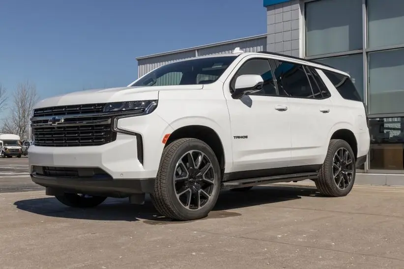 White Chevrolet Tahoe SUV parked outside a dealership, showcasing its modern design and performance features, relevant to Chevrolet maintenance tips.