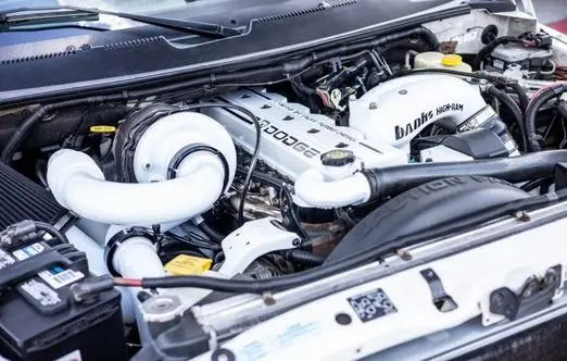 Dodge engine compartment showcasing high-performance components and turbocharger, emphasizing automotive maintenance and repair expertise.