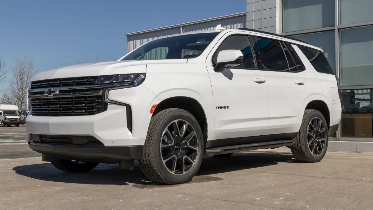 White Chevrolet Tahoe SUV parked outside a dealership, showcasing its modern design and alloy wheels, representing expert Chevrolet service and repair at Deutmeyer Auto Advantage in Dyersville, IA.