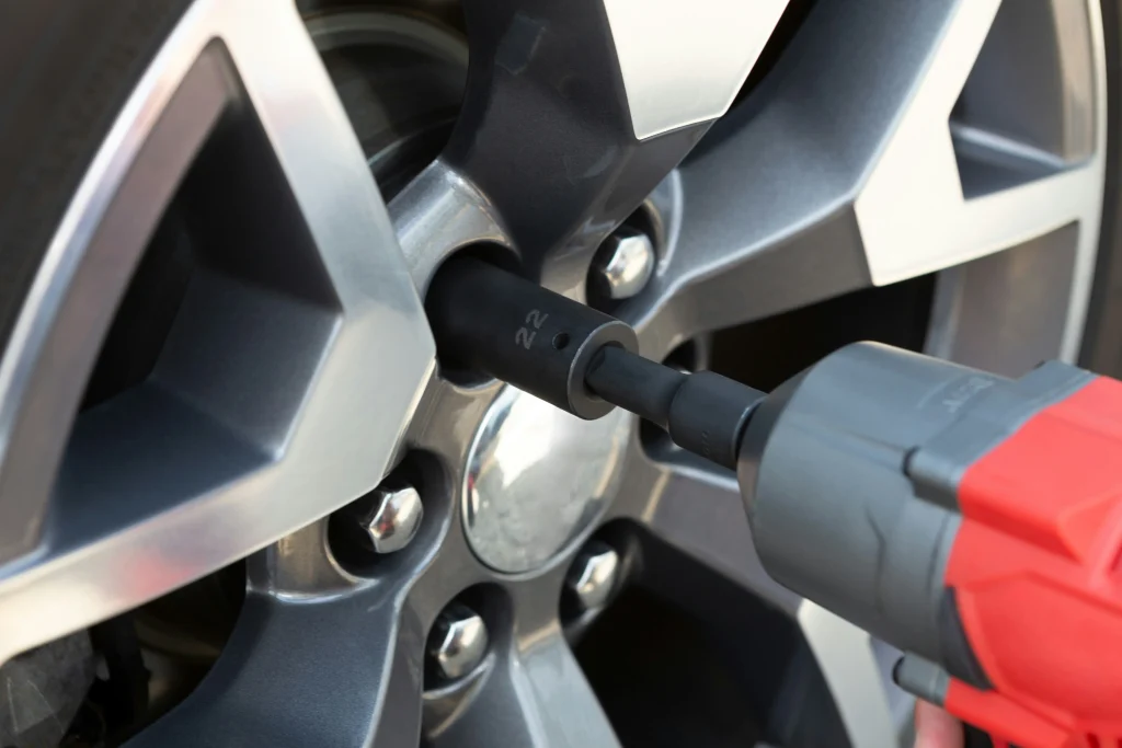 Close-up of a tire being serviced with a power tool, highlighting the importance of tire maintenance in automotive safety and performance.