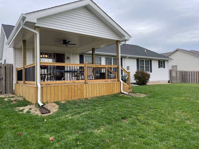 Custom deck built by Sutton’s with a roof overhead and decorative railings in Springfield IL