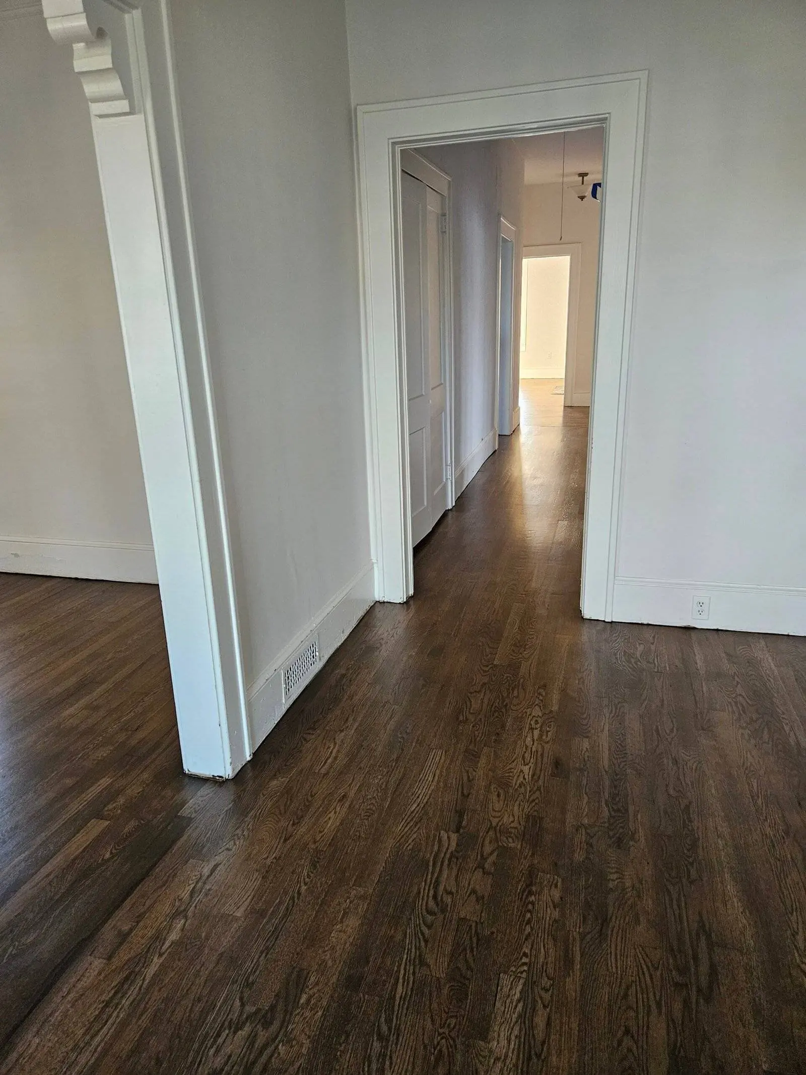 Hallway interior showcasing newly repaired hardwood flooring and white walls, illustrating successful water damage restoration by Advanced Restoration SC.