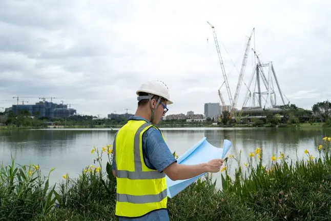 A young Asian male engineer working at a construction site