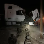 A white truck with its front end and the hood open