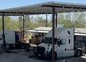 a white semi truck parked under a covered canopy